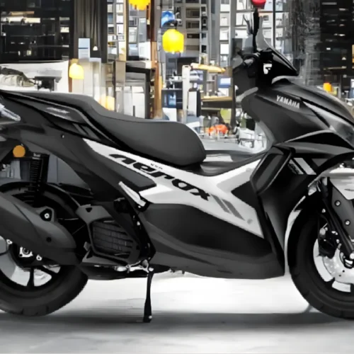 Side view of Yamaha Aerox 155 with rider on urban road